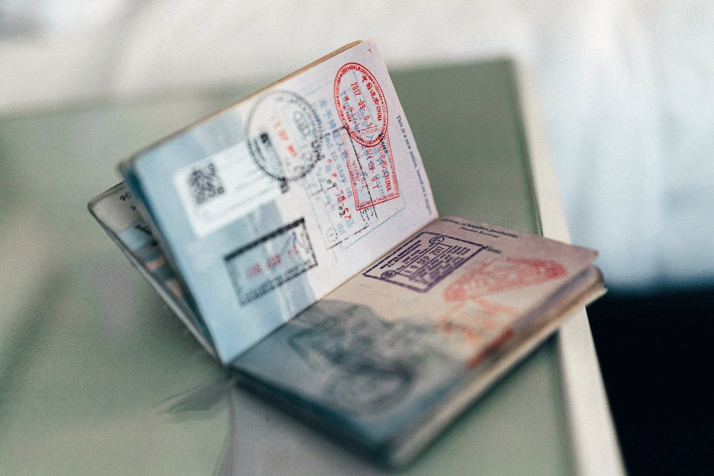 Розгорнутий закордонний паспорт зі штампами й візами